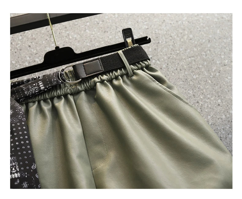 Grüne Lederhose mit elastischem Bund und schwarzem Gürtel, modische Damenbekleidung.
