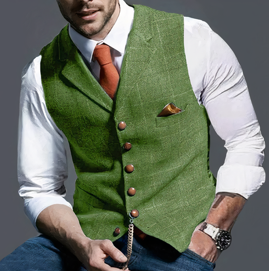 Mann in grünem Trachtenweste, weißem Hemd, orangefarbener Krawatte, eleganter Look.