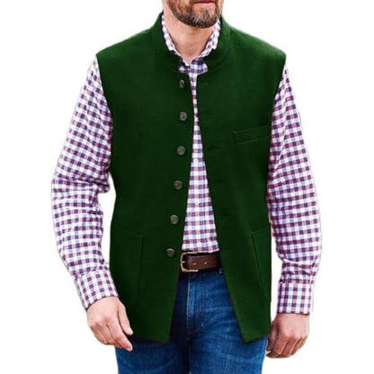 Mann in grüner Trachtenweste, kariertes Hemd, blaue Jeans, traditionelles bayerisches Outfit.