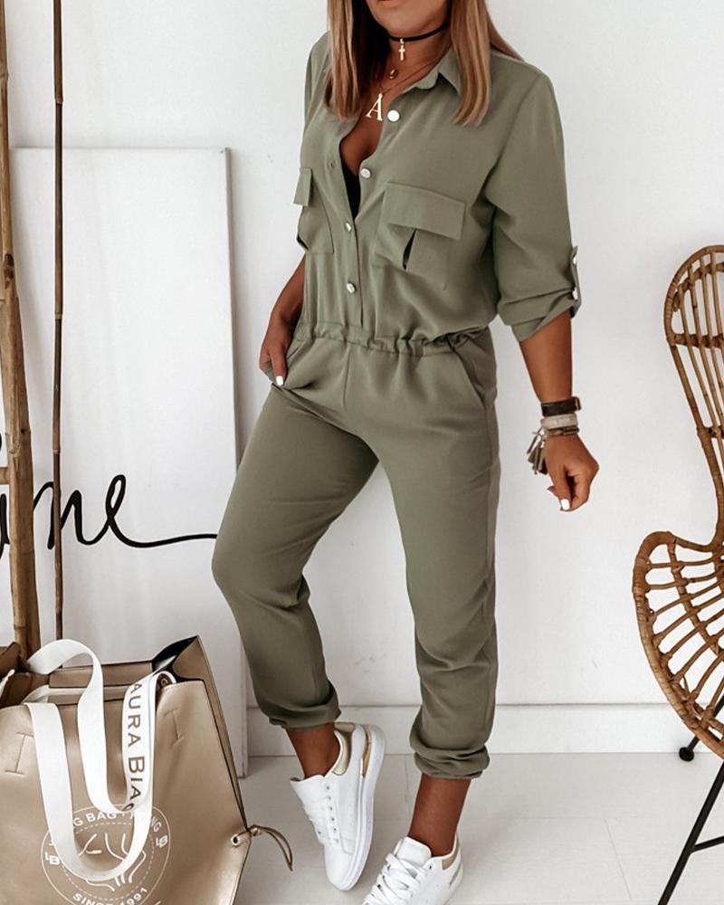 Frau in olivgrünem Jumpsuit, lässig, mit weißen Sneakers, modisch, Freizeitkleidung.