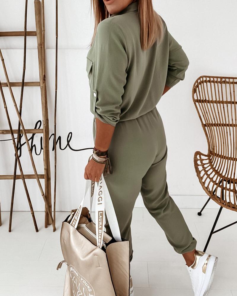 Frau in grünem Jumpsuit mit beiger Tasche, weiße Sneaker, modisch, lässig, modern.
