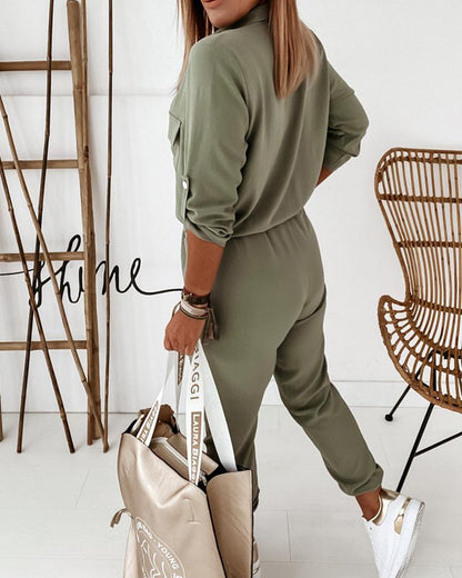 Frau in grünem Jumpsuit mit beiger Tasche, weiße Sneaker, modisch, lässig, modern.