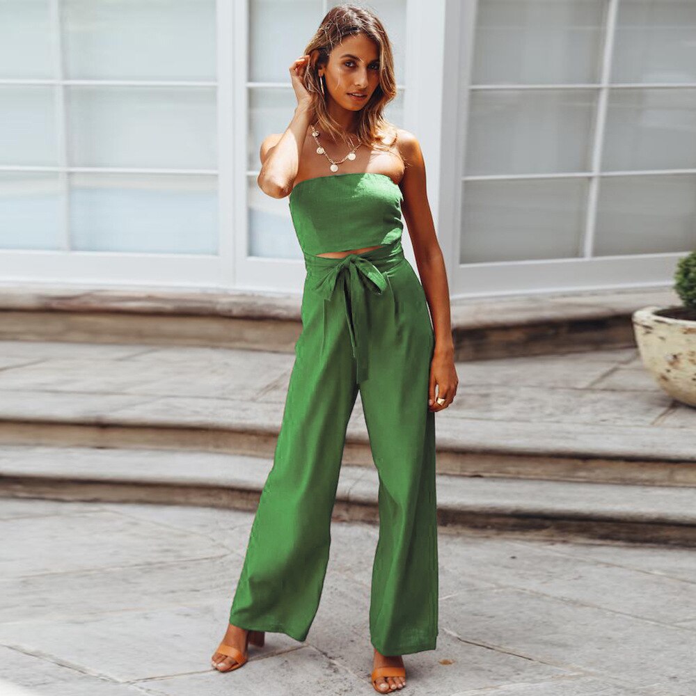 Frau in grünem Jumpsuit, ärmellos, mit Schleife, modisch, Sommerkleidung, draußen.