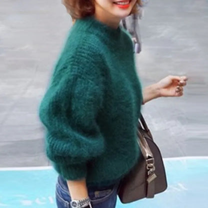 Frau in grünem Strickpullover, trägt braune Umhängetasche, lässiger Herbstlook.