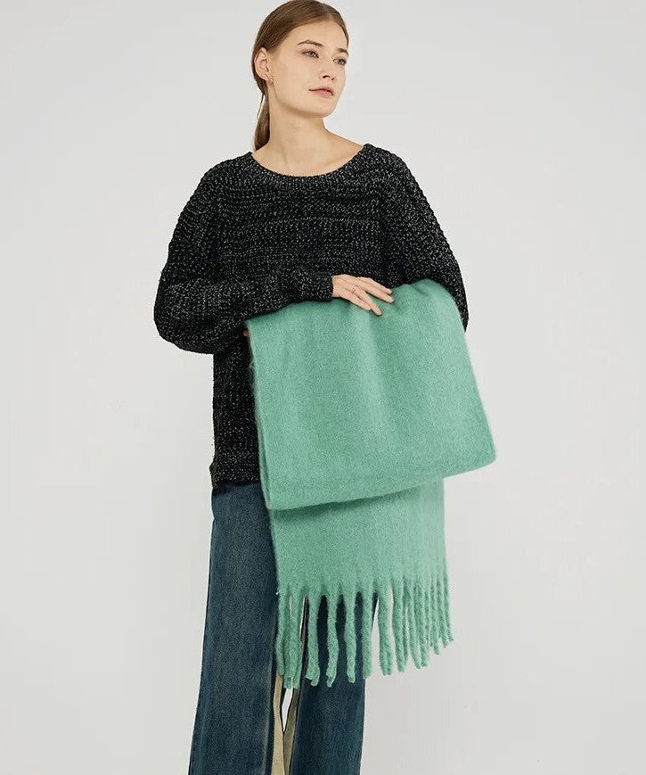 Frau mit grünem Wollschal und schwarzem Pullover, modisch, Herbstbekleidung, Damenmode.