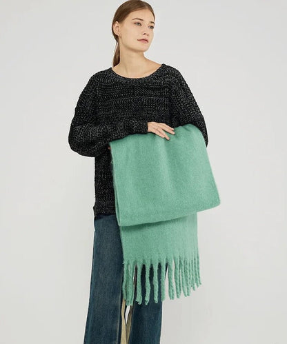Frau mit grünem Wollschal und schwarzem Pullover, modisch, Herbstbekleidung, Damenmode.