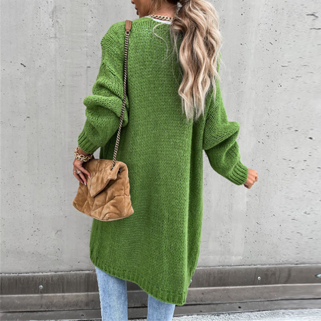 Frau in grünem Strickpullover, blaue Jeans, braune Tasche, lässiger Herbstlook, Rückansicht.