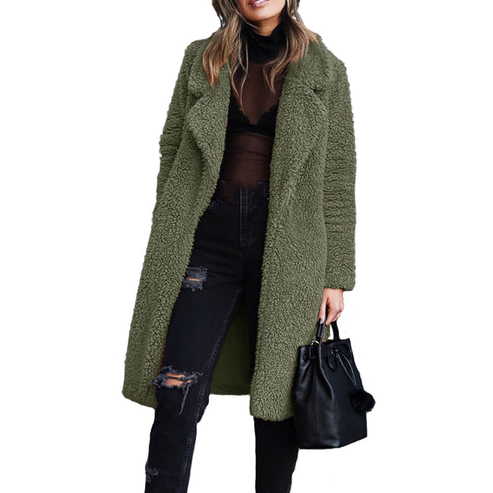 Frau in grünem Teddy-Mantel, schwarze Jeans, schwarze Tasche, modisch, Herbst-Winter-Outfit.