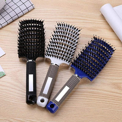 Drei belüftete Haarbürsten in Schwarz, Weiß und Blau auf Holztisch, ideal zum schnellen Trocknen.