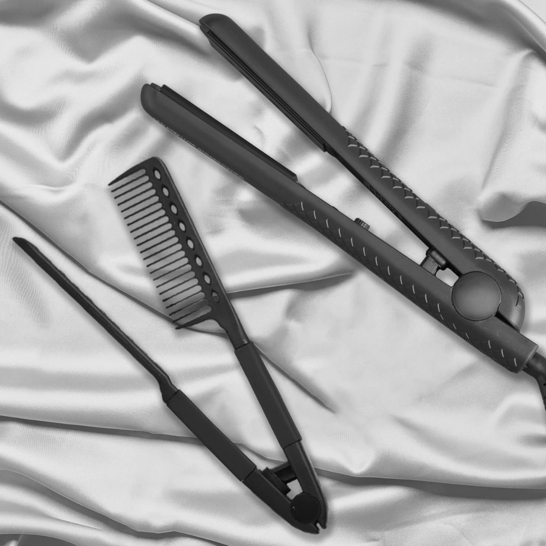 Schwarzes Glätteisen und Kamm auf weißem Seidenstoff, Haarstyling-Set, elegant, modern.
