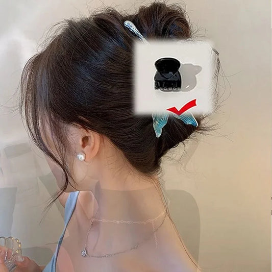 Frau mit braunem Dutt, verziert mit blauem Schmetterlings-Haarclip, eleganter Look.