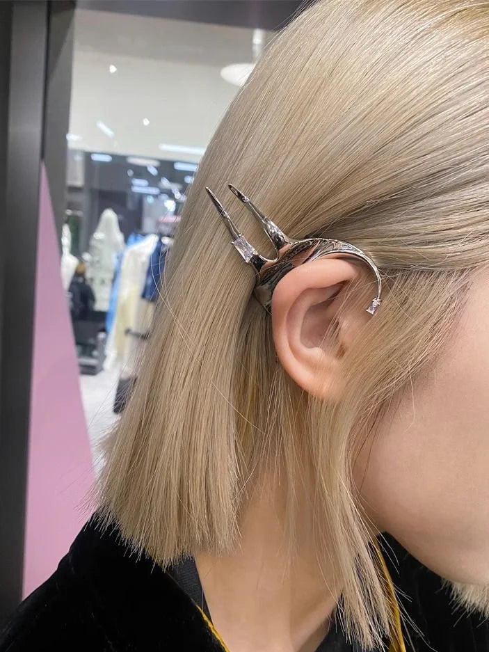 Silberne Haarspange in Form eines Dolches, getragen in blondem Haar, modisches Accessoire.
