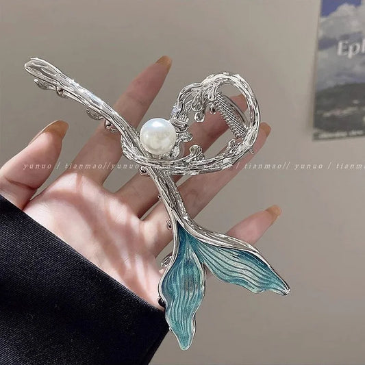 Silberne Haarspange mit Perle und blauen Blättern, elegantes Design, modisches Accessoire.