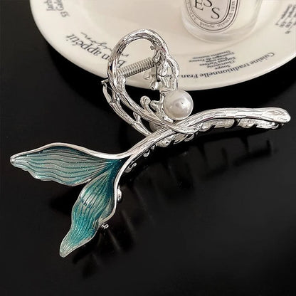 Silberne Haarspange mit Perle und blauen Flossen, elegantes Design, modisches Accessoire.