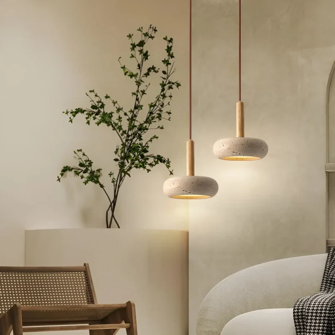 Zwei moderne Hängelampen aus Beton und Holz in minimalistischem Wohnzimmer mit Pflanze.