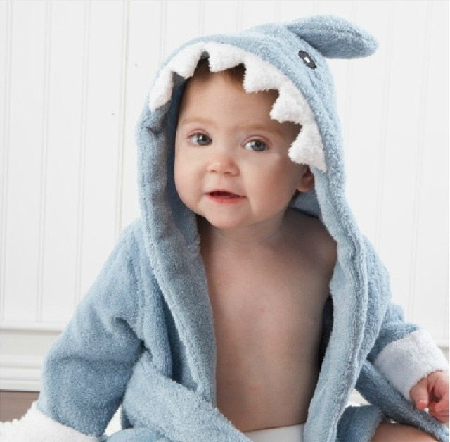 Baby in blauem Haifisch-Bademantel, Kapuze mit Zähnen, weiches Frottee, niedliche Kinderbekleidung.