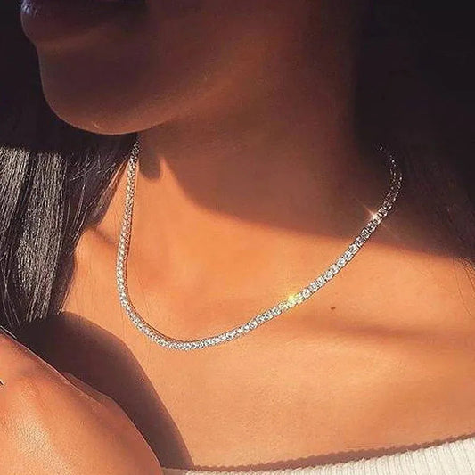 Frau trägt funkelnde Silberkette, elegantes Schmuckstück, modisches Accessoire, Nahaufnahme.