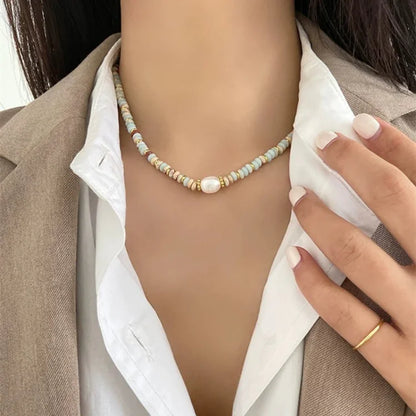Frau mit Perlenkette, bunte Steine, elegantes Schmuckdesign, modisches Accessoire, Nahaufnahme.
