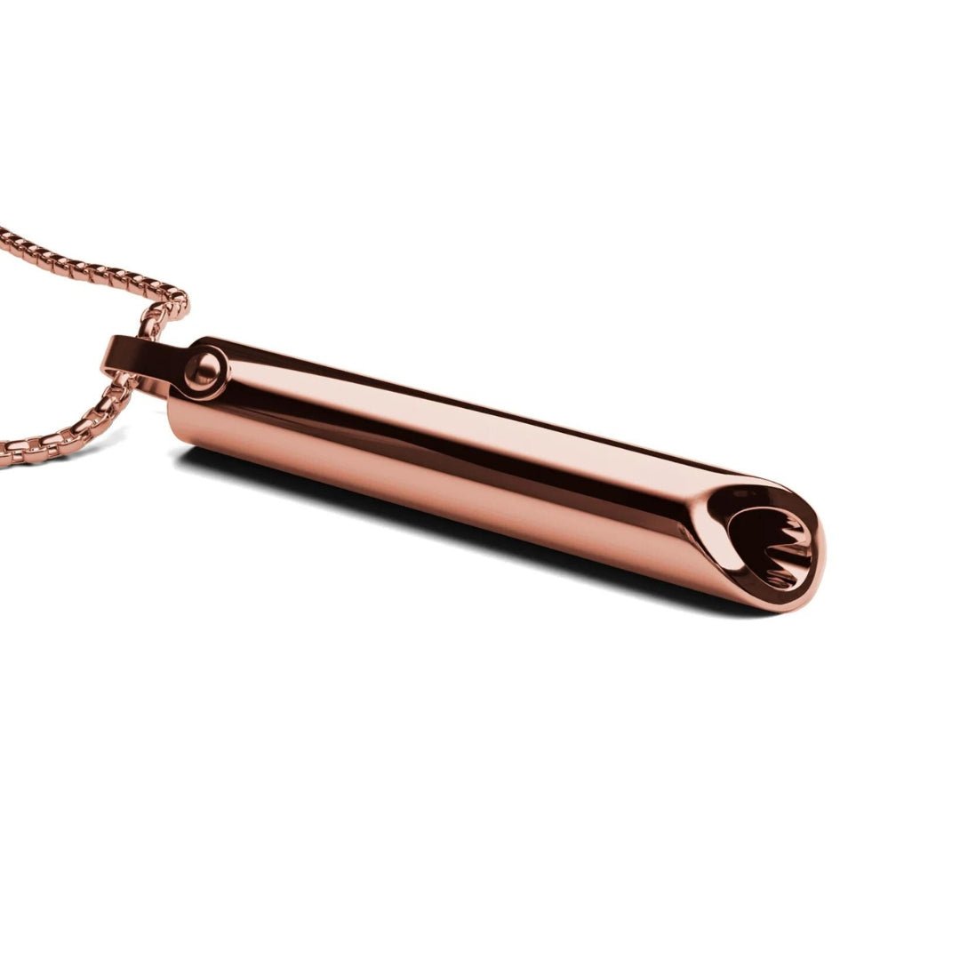 Roségoldener Kettenanhänger in Zylinderform, elegantes Schmuckdesign, glänzende Oberfläche.