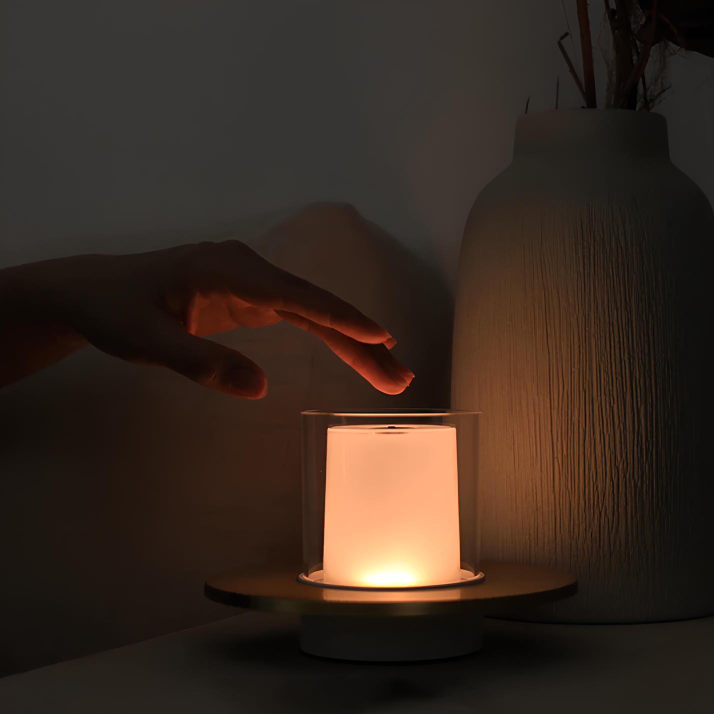 Hand berührt LED-Kerze auf Holzuntersetzer, warmes Licht, moderne Dekoration, Wohnzimmer.