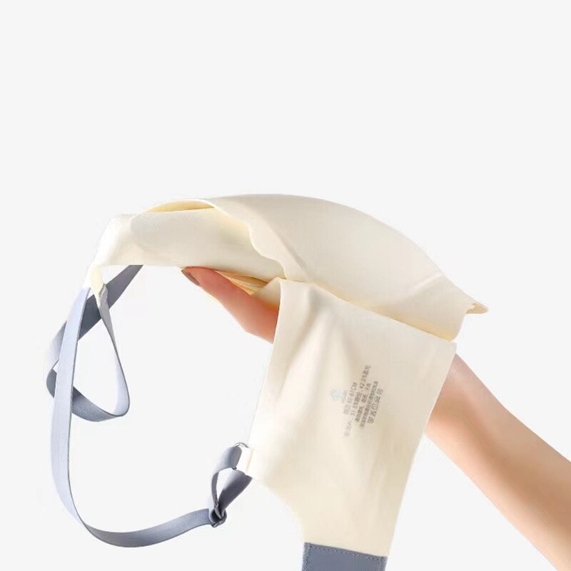 Hand hält beigen BH mit grauen Trägern, nahtlos, bequem, Damenunterwäsche.