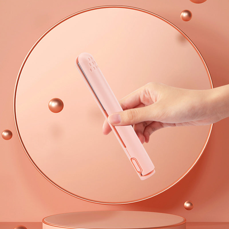 Hand hält rosa kabelloses Haarglätter, tragbar, leicht, ideal für unterwegs, stilvolles Design.