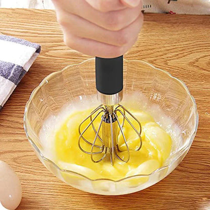 Handmixer aus Edelstahl in Glasschüssel, ideal zum Eier schlagen, Küchenutensil, Holzoberfläche.