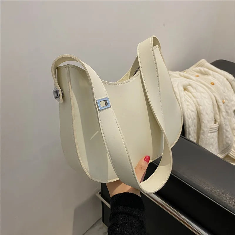 Beige Lederhandtasche mit breitem Schultergurt, modisches Accessoire für Damen.