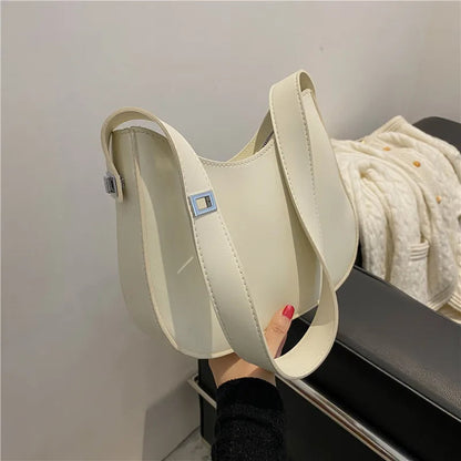 Beige Lederhandtasche mit breitem Schultergurt, modisches Accessoire für Damen.