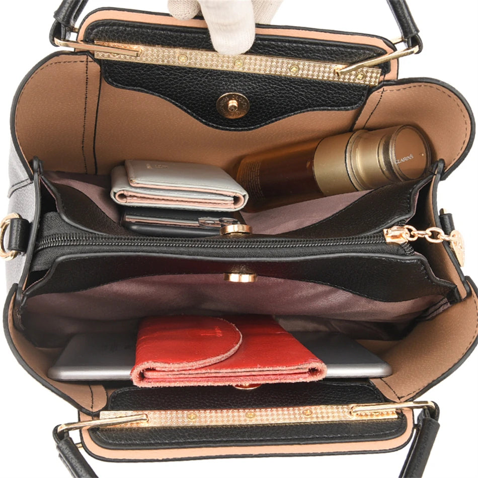 Offene schwarze Handtasche aus Leder mit Fächern, Geldbörse, Kosmetik und Tablet.