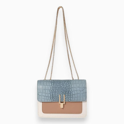 Blaue Damenhandtasche mit Krokodilleder-Optik, goldener Kette, beige und weißem Design.