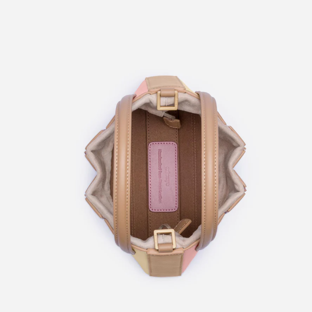 Braune Lederhandtasche mit pastellfarbenen Akzenten, runde Form, modisches Accessoire.