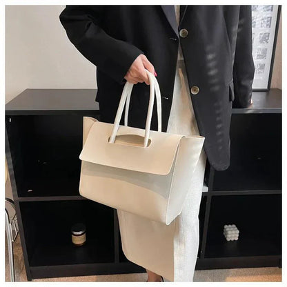 Frau mit weißer Ledertasche, elegantes Design, Büro-Outfit, schwarze Jacke, moderne Mode.
