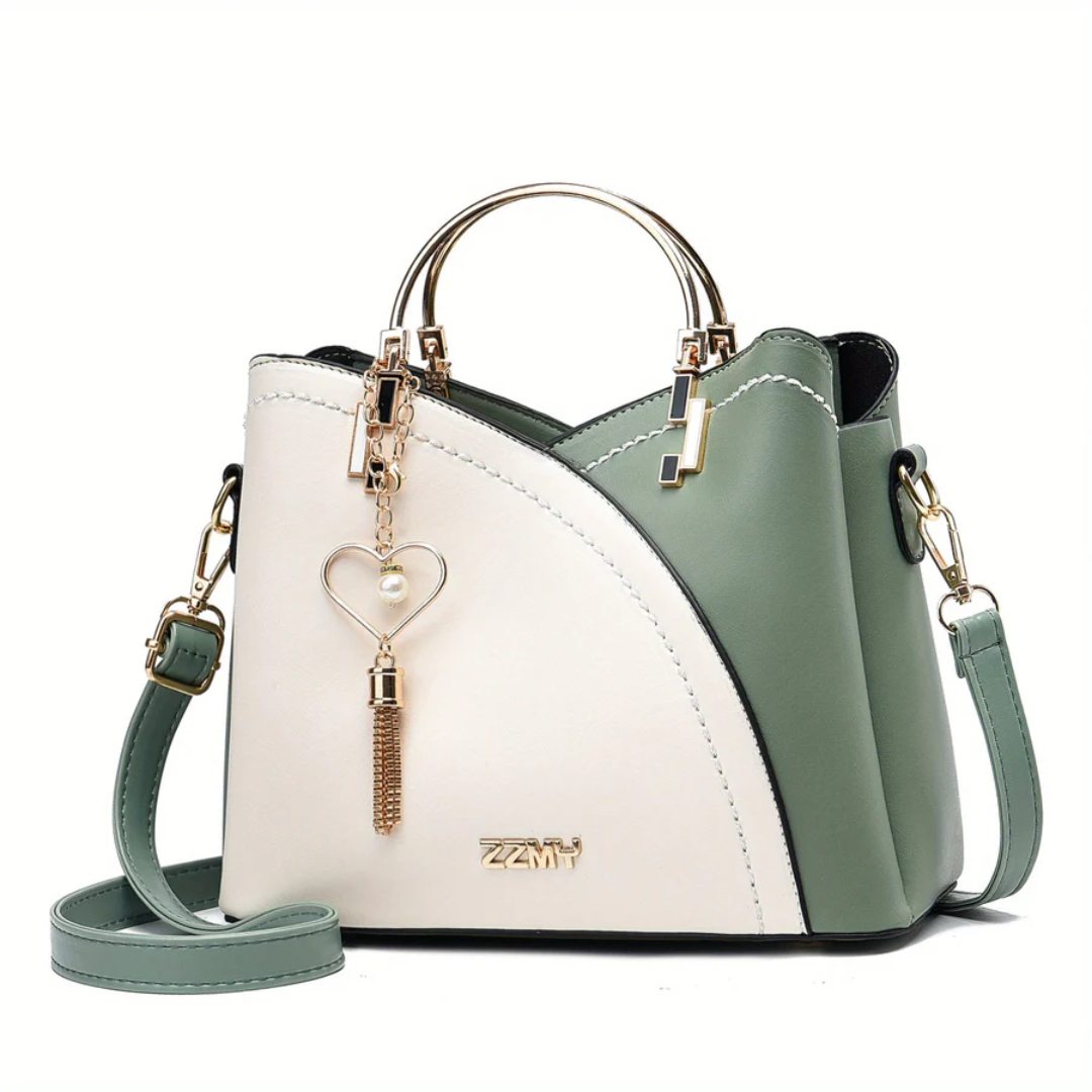 Grüne und weiße Damenhandtasche aus Leder mit goldenen Details und Herzanhänger.