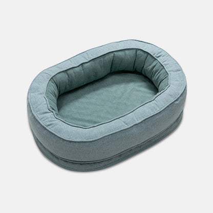 Ovales, blaues Hundebett aus Stoff, gemütlich und waschbar, ideal für kleine Hunde.