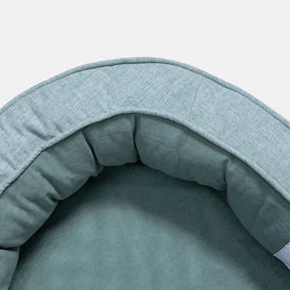 Graues Hundebett aus Stoff, rund, gemütlich, ideal für Haustiere, waschbar, langlebig.