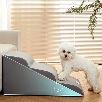 Graue Hundetreppe mit 27° Neigung, ideal für kleine Hunde, neben Sofa, weißer Pudel.