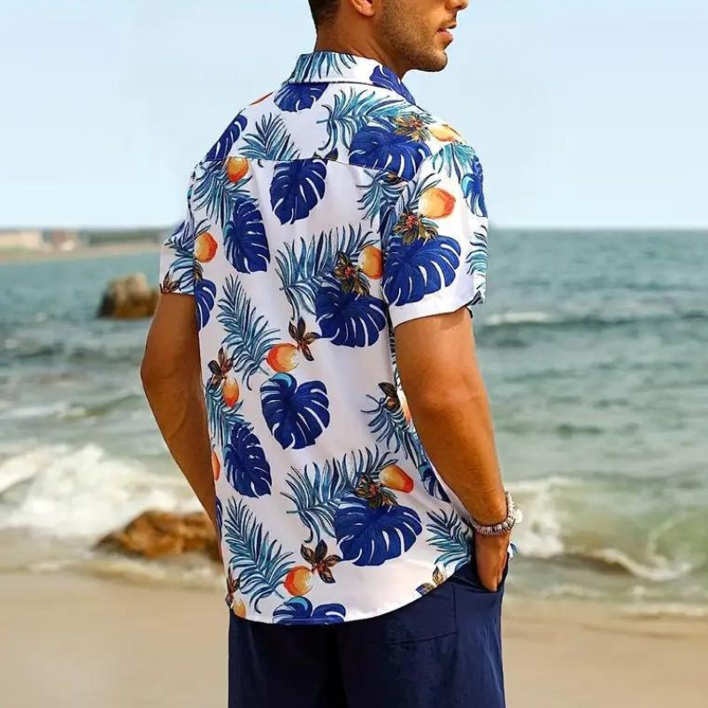 Mann im weißen Hawaiihemd mit blauem Blattmuster am Strand, Sommermode, Freizeitkleidung.