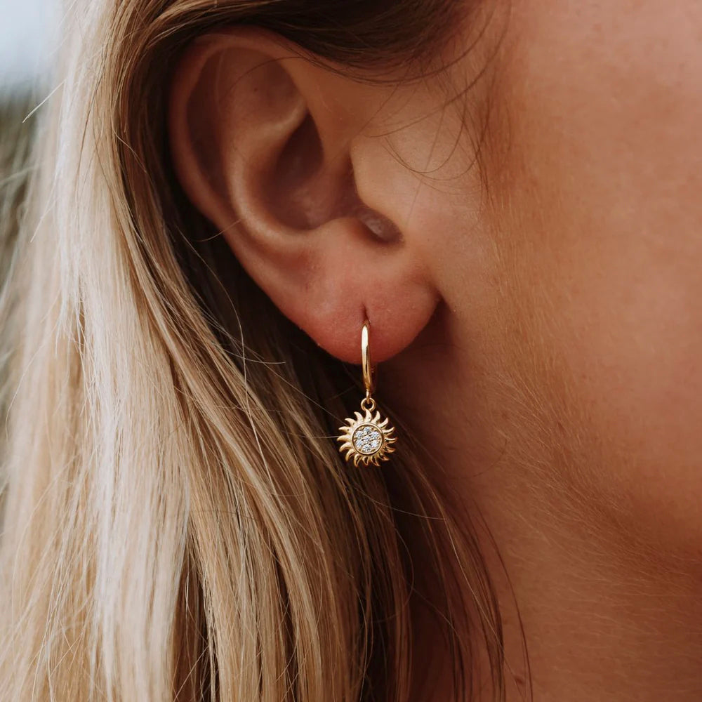 Goldene Creolen mit Sonnenanhänger, Damen Ohrringe, modischer Schmuck, elegant, stilvoll.