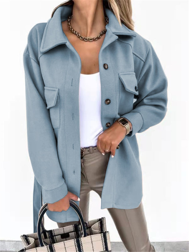 Frau in hellblauer Wolljacke, weiße Bluse, beige Hose, kariertes Handtasche, modisch, elegant.