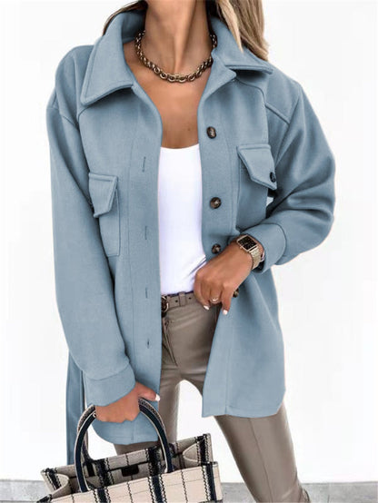 Frau in hellblauer Wolljacke, weiße Bluse, beige Hose, kariertes Handtasche, modisch, elegant.