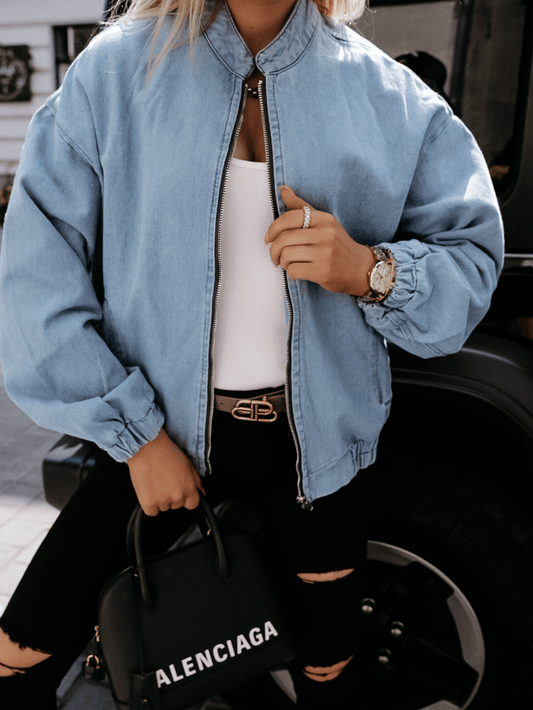 Frau in blauer Jeansjacke, weißem Top, schwarze Tasche, zerrissene Jeans, modisch, urban.