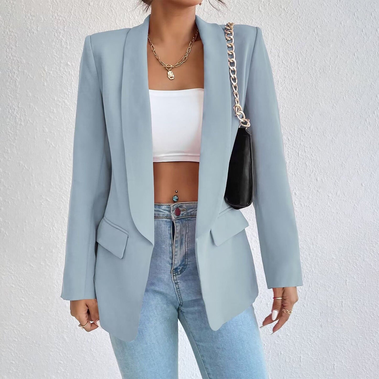 Frau in hellblauem Blazer, weißem Top, Jeans; modischer Look, eleganter Stil, Damenmode.