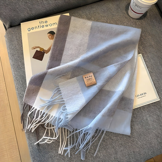 Hellblauer Kaschmirschal mit Fransen auf Zeitschrift, elegantes Accessoire, weiches Material.