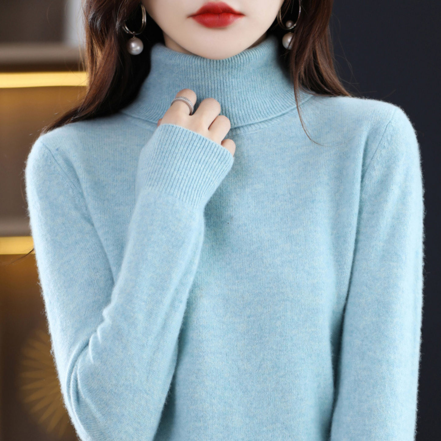 Frau in hellblauem Rollkragenpullover aus Kaschmir, elegante Wintermode, Nahaufnahme.