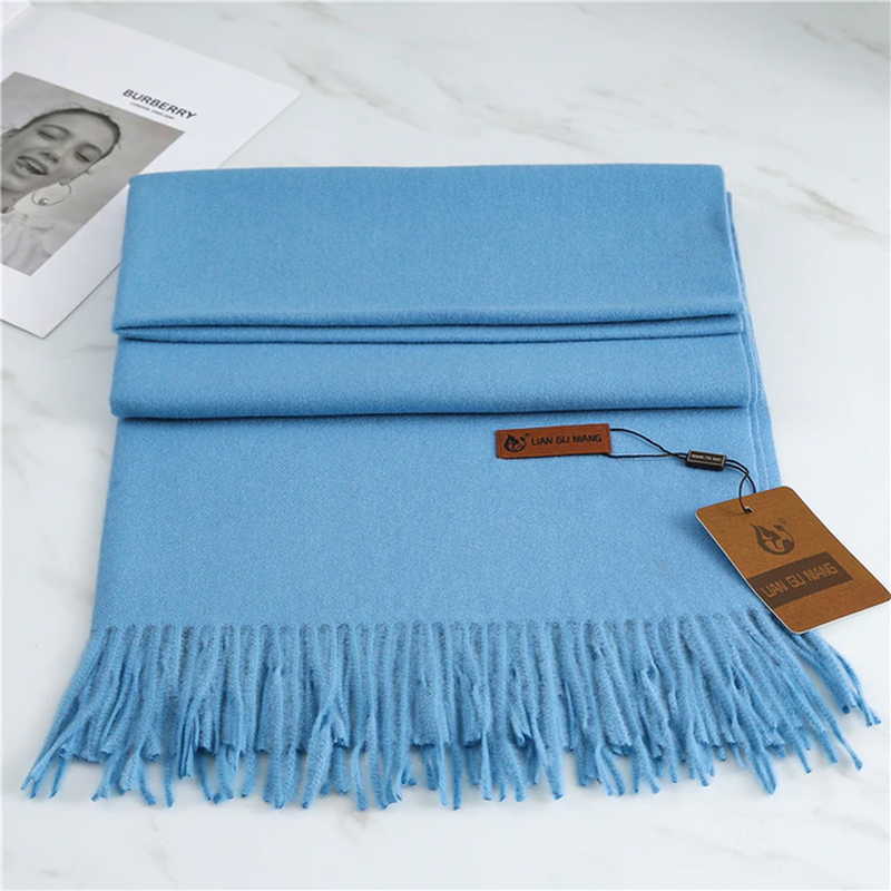 Blaue Kaschmirschal mit Fransen, weiches Material, modisches Accessoire, luxuriöses Design.