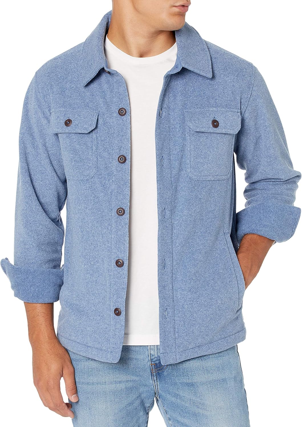 Mann in blauer Flanelljacke mit Knöpfen, weißem T-Shirt und Jeans.