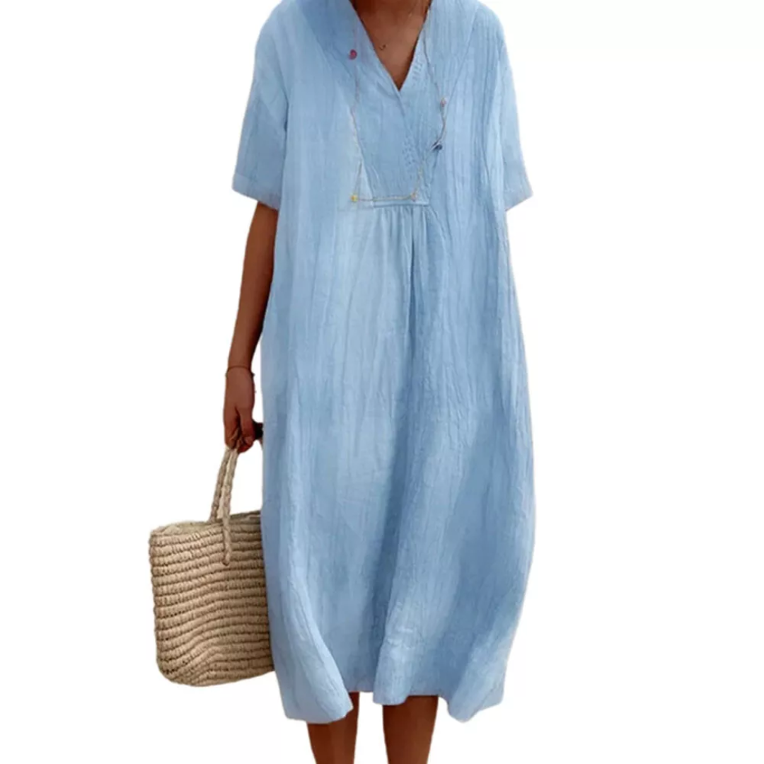 Frau in hellblauem Leinenkleid mit V-Ausschnitt, hält Strohtasche, Sommermode.