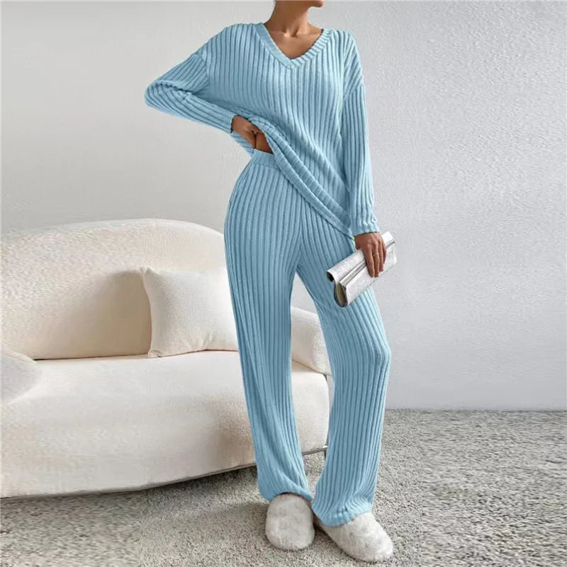 Frau in hellblauem Strick-Loungewear-Set, V-Ausschnitt, gemütlich, modisch, Wohnzimmer.