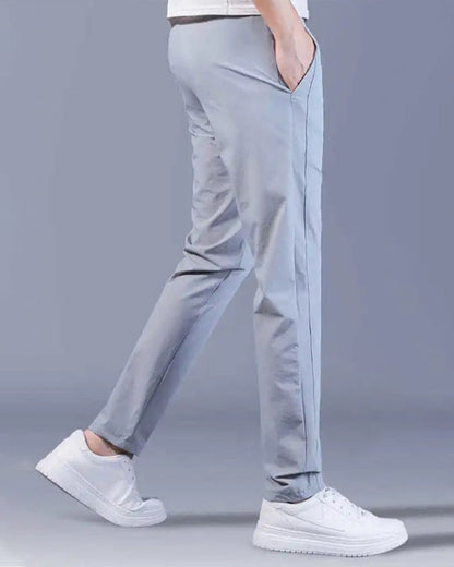 Graue Herren-Chinohose, schmal geschnitten, Baumwolle, lässig, mit weißen Sneakern.